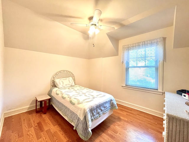 bedroom featuring hardwood / wood-style floors, vaulted ceiling, and ceiling fan