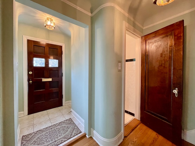 foyer featuring ornamental molding and light hardwood / wood-style flooring