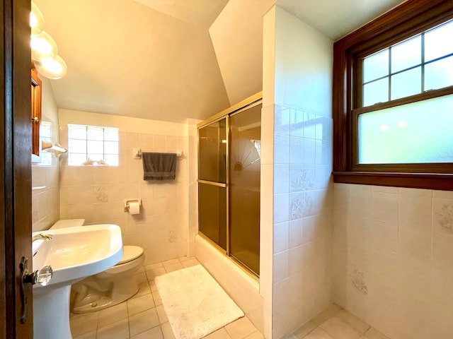 bathroom with toilet, tile walls, plenty of natural light, and tile patterned flooring