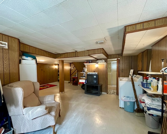 basement featuring washing machine and dryer and wooden walls