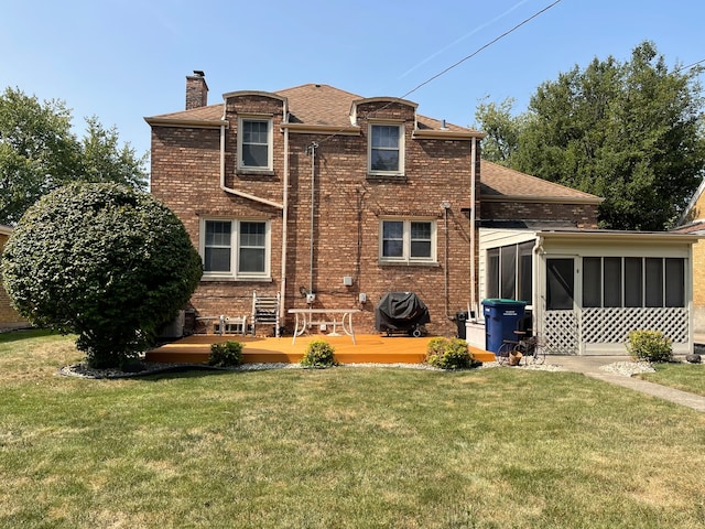 back of house featuring a sunroom and a lawn