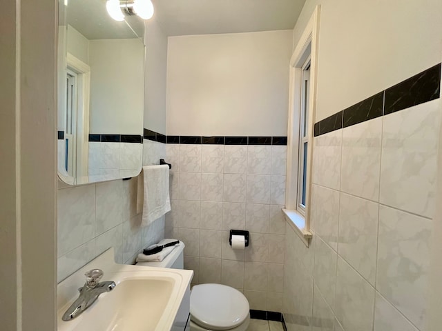 bathroom featuring tile walls, sink, and toilet