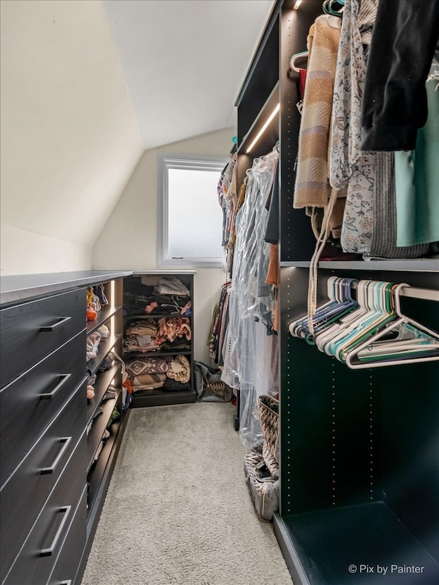 walk in closet featuring light carpet and lofted ceiling