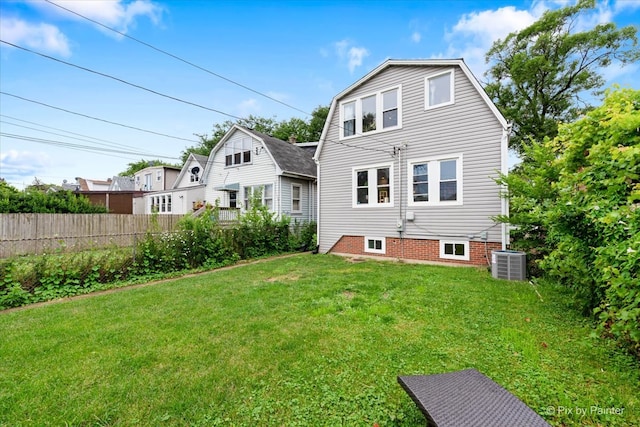 rear view of house featuring a yard and central AC unit