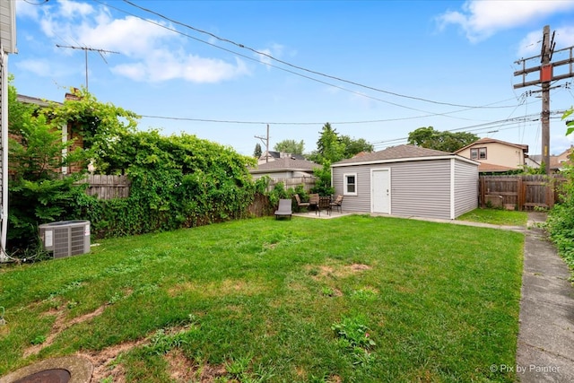 view of yard featuring central air condition unit and a storage unit