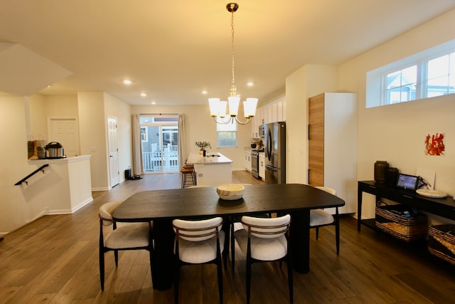 dining area with dark hardwood / wood-style floors and a notable chandelier