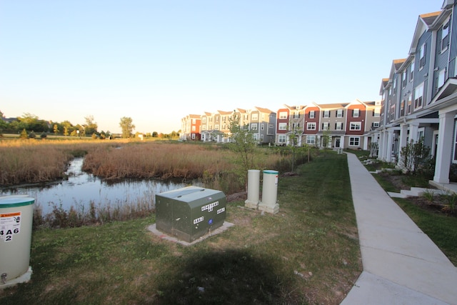 exterior space with a water view and a lawn