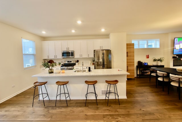 kitchen featuring plenty of natural light, appliances with stainless steel finishes, and a kitchen island with sink