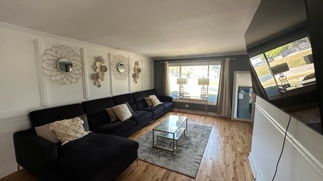 living room with light hardwood / wood-style flooring and ornamental molding