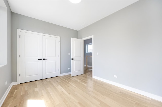 unfurnished bedroom with a closet and light hardwood / wood-style flooring