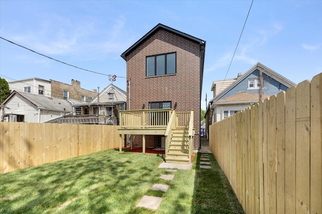 rear view of property with a lawn and a deck