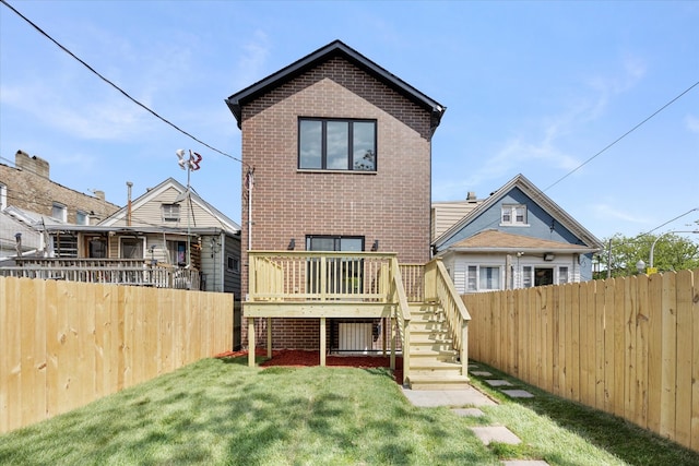 rear view of property with a lawn and a wooden deck