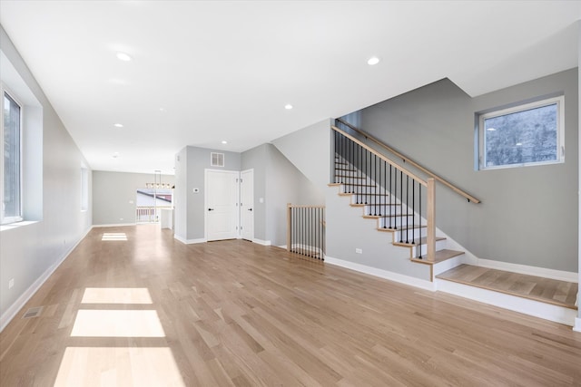 unfurnished living room featuring plenty of natural light and light hardwood / wood-style flooring