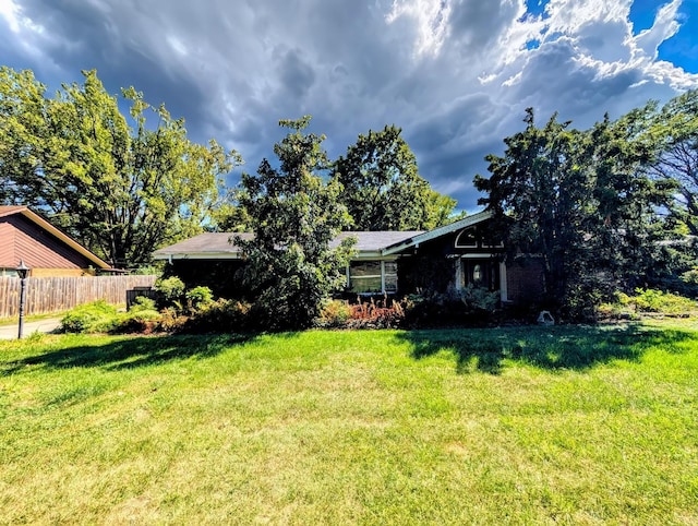 view of front of house featuring a front lawn and fence