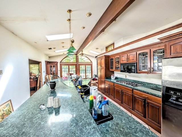 kitchen with decorative light fixtures, french doors, beam ceiling, stainless steel appliances, and dark stone counters