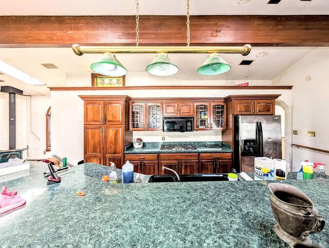 kitchen featuring beamed ceiling and stainless steel appliances