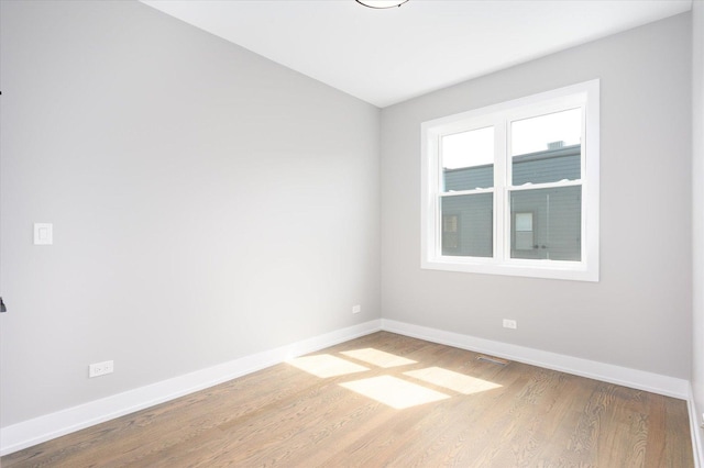 empty room featuring wood finished floors and baseboards