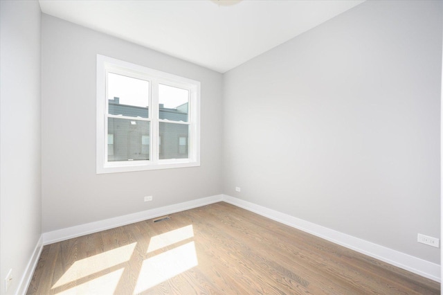 empty room with baseboards and wood finished floors