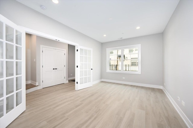 unfurnished room featuring light wood-style flooring, baseboards, french doors, and recessed lighting