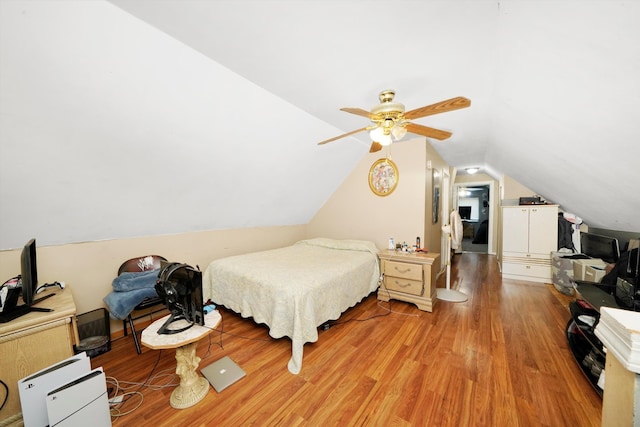 bedroom with vaulted ceiling, light wood-style floors, and ceiling fan