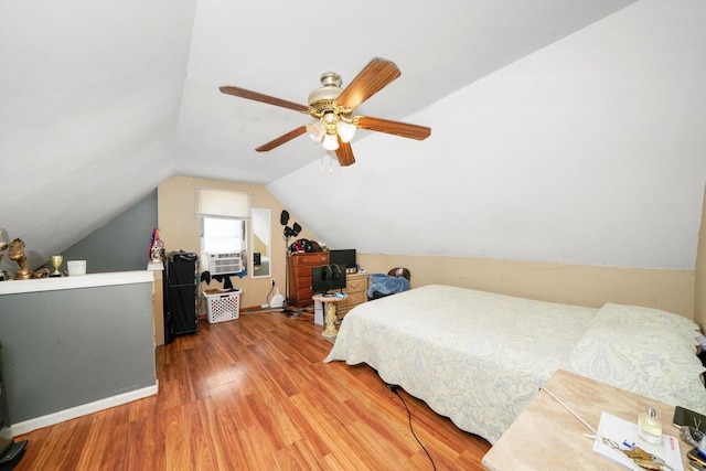 bedroom featuring a ceiling fan, lofted ceiling, and wood finished floors