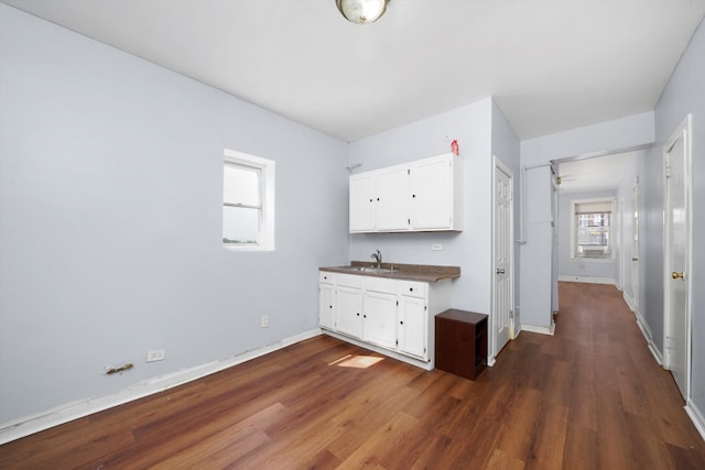 kitchen featuring white cabinetry, dark countertops, dark wood-style floors, and baseboards