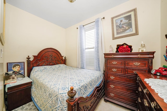 bedroom featuring light tile patterned flooring and vaulted ceiling