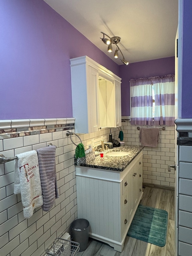 bathroom with vanity, hardwood / wood-style floors, and tile walls