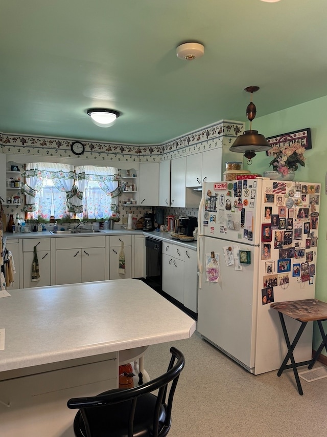 kitchen with dishwasher, backsplash, hanging light fixtures, white cabinetry, and white refrigerator