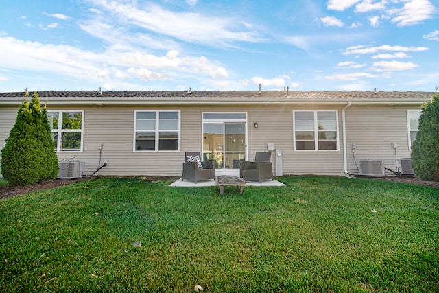 rear view of property featuring a lawn, a patio, and central air condition unit