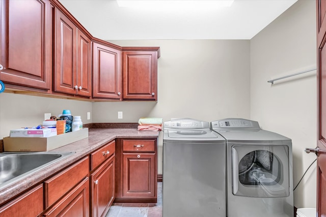 washroom with sink, cabinets, and washing machine and dryer