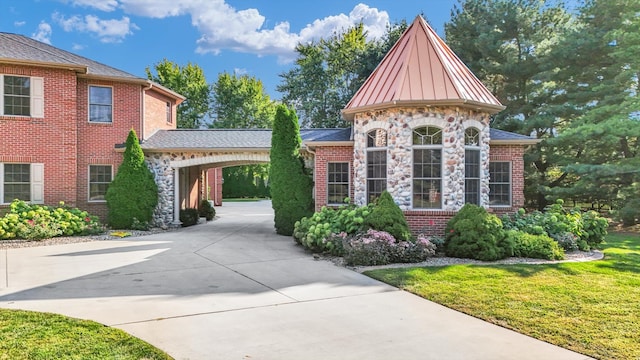 view of front of house with a carport and a front lawn