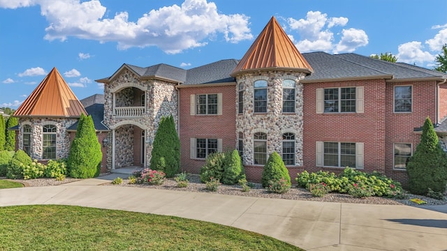 view of front of home with a front lawn and a balcony