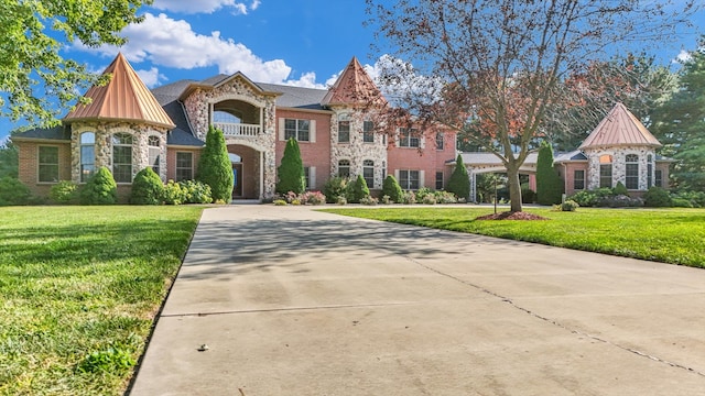 view of front of home featuring a balcony and a front lawn