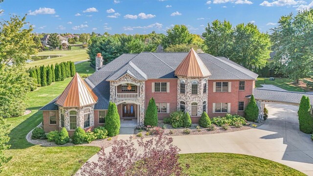 4703 W Kirby Ave, Champaign, IL 61822 - view of front of property featuring stone siding, a front yard, curved driveway, a chimney, and brick siding