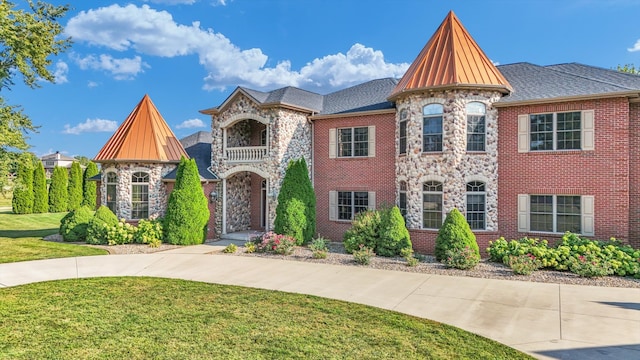 view of front of property featuring a balcony and a front lawn