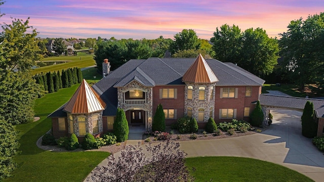 4703 W Kirby Ave, Champaign, IL 61822 - view of front of home with curved driveway, stone siding, a lawn, a standing seam roof, and a chimney