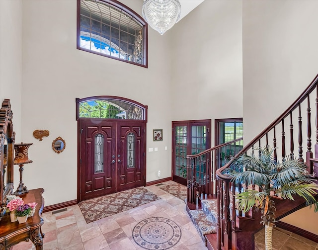 foyer with a towering ceiling and a notable chandelier