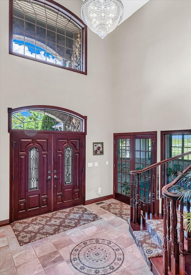 entryway with a towering ceiling and a notable chandelier