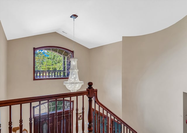 stairs with a chandelier and vaulted ceiling