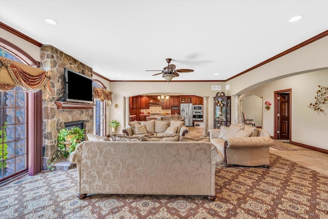 living room with ceiling fan, a fireplace, and ornamental molding