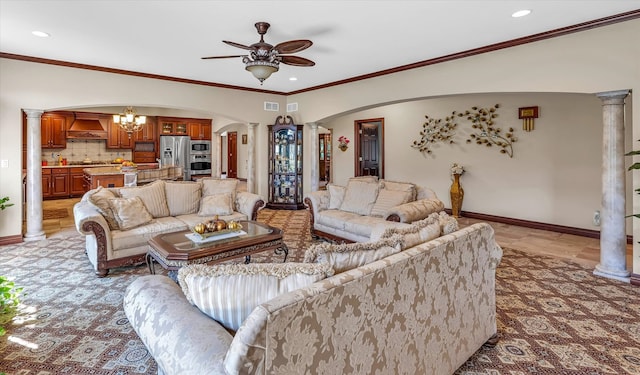 living room featuring crown molding, ceiling fan with notable chandelier, and ornate columns