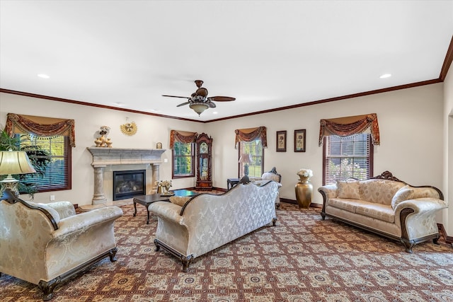 carpeted living room with ceiling fan, a wealth of natural light, a high end fireplace, and ornamental molding