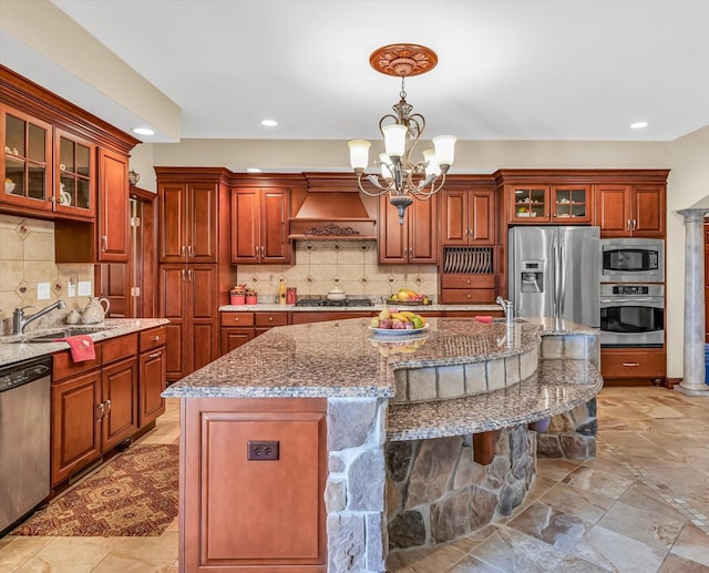 kitchen featuring pendant lighting, tasteful backsplash, stainless steel appliances, an inviting chandelier, and a center island with sink