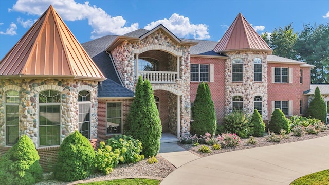4703 W Kirby Ave, Champaign, IL 61822 - view of front of home featuring a balcony, stone siding, brick siding, a standing seam roof, and a shingled roof