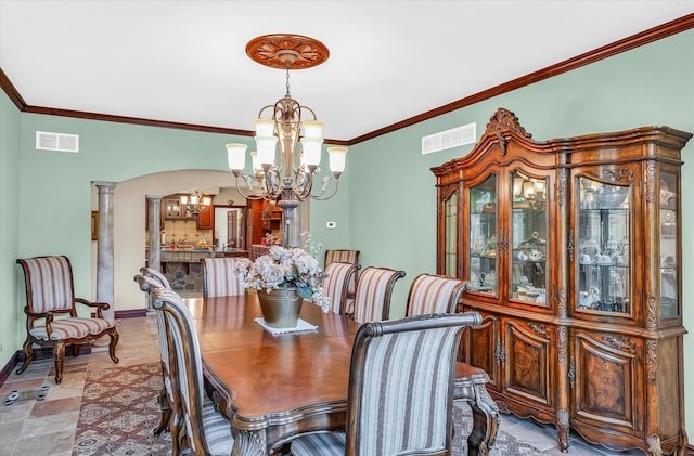 dining space with ornamental molding, ornate columns, and an inviting chandelier