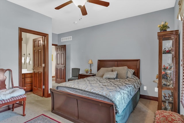 bedroom with ceiling fan, light carpet, and ensuite bathroom