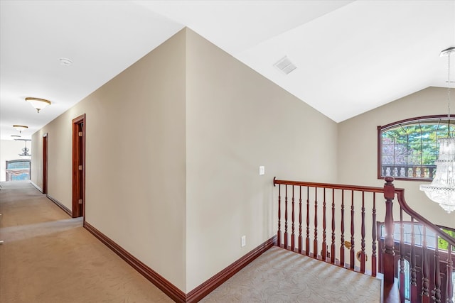 hall featuring lofted ceiling, plenty of natural light, and light colored carpet