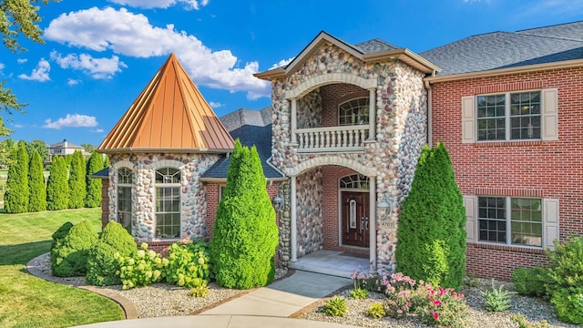 4703 W Kirby Ave, Champaign, IL 61822 - view of front facade featuring a balcony, stone siding, a front lawn, and brick siding