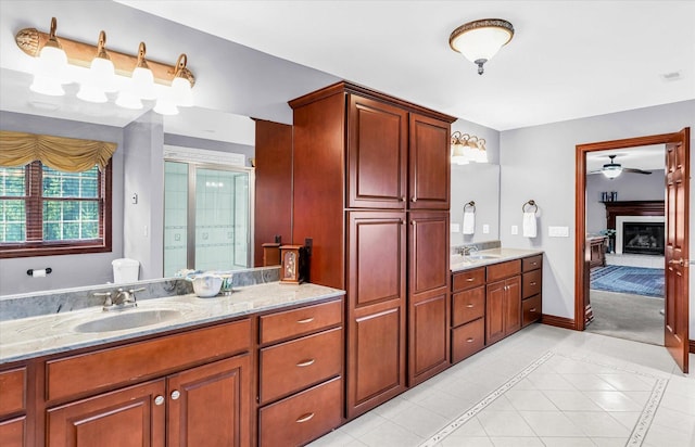 4703 W Kirby Ave, Champaign, IL 61822 - ensuite bathroom with double vanity, a ceiling fan, tile patterned flooring, and a glass covered fireplace